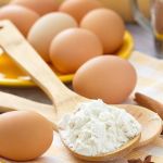 Viele Eier ein Holzlöffel mit Mehl und ein paar Stangen Zimt und Anissterne
